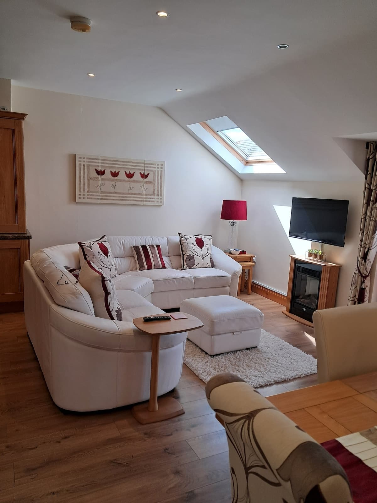 Inviting light-filled lounge with cream seating, skylight and fireplace