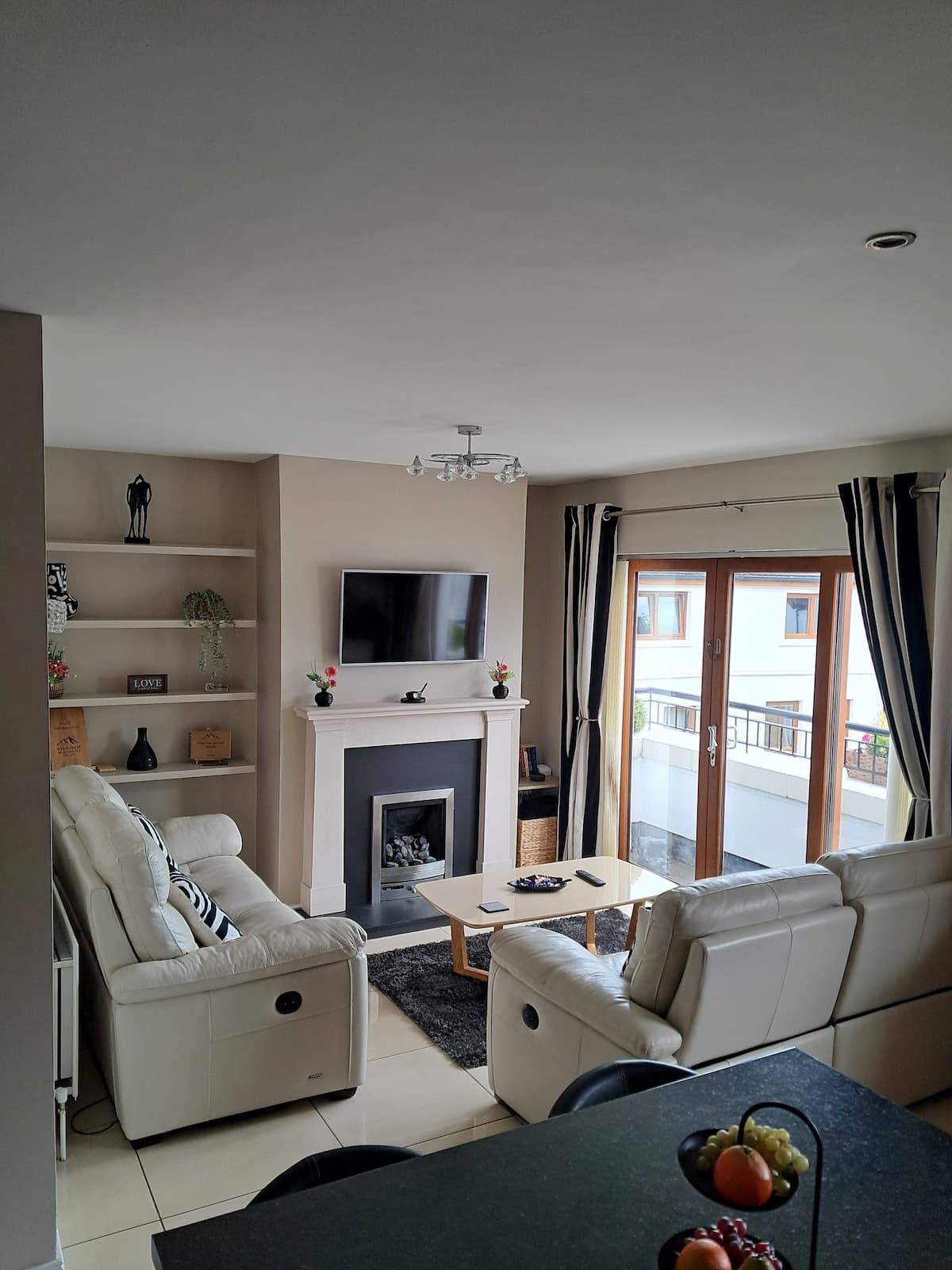 The Brooks apartment with cream seating, fireplace and balcony doors